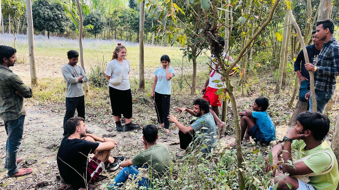 Children participating in outdoor learning activities under the shade of trees