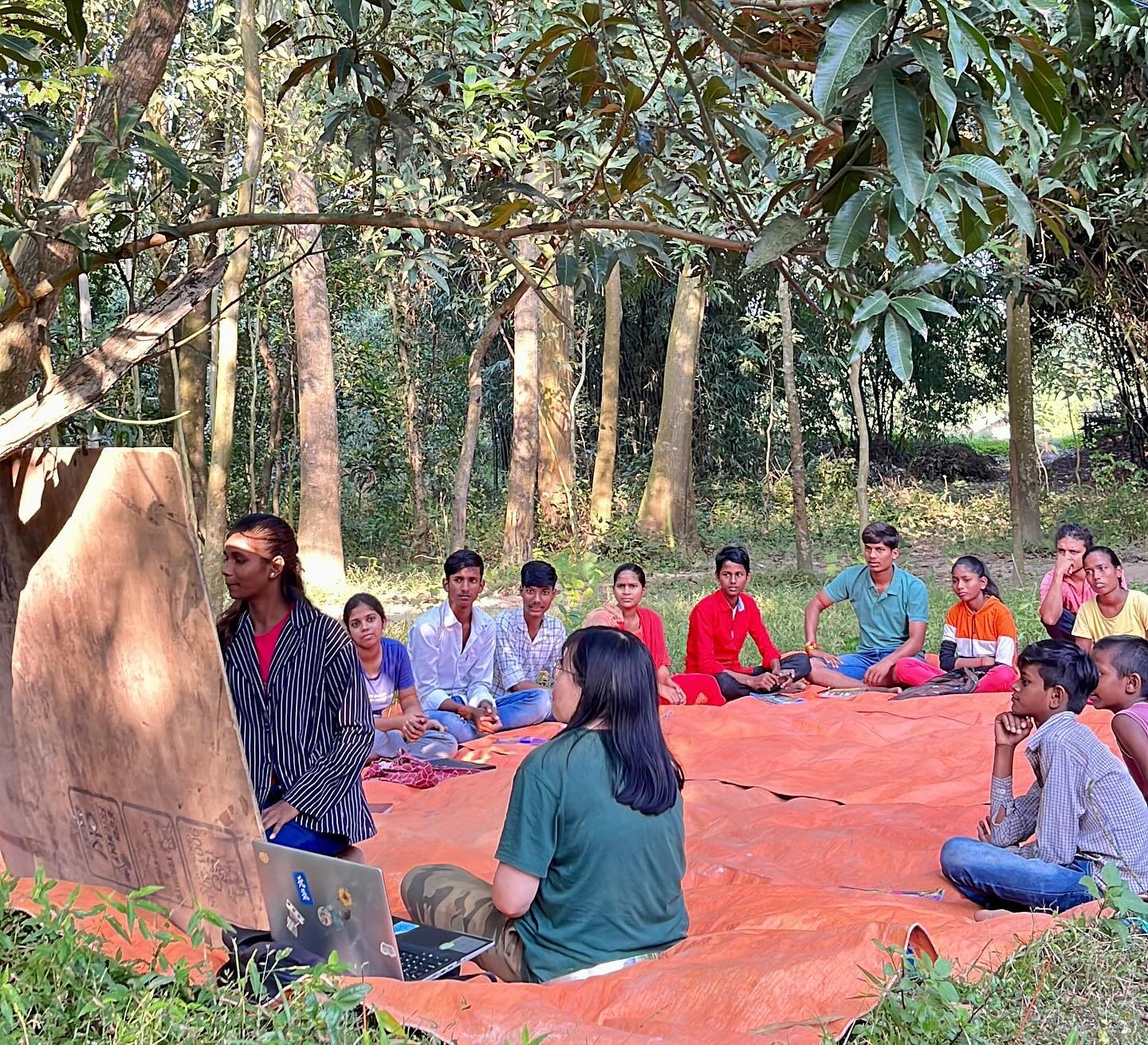 Women mentors teaching teenage girls vocational skills in a workshop setting