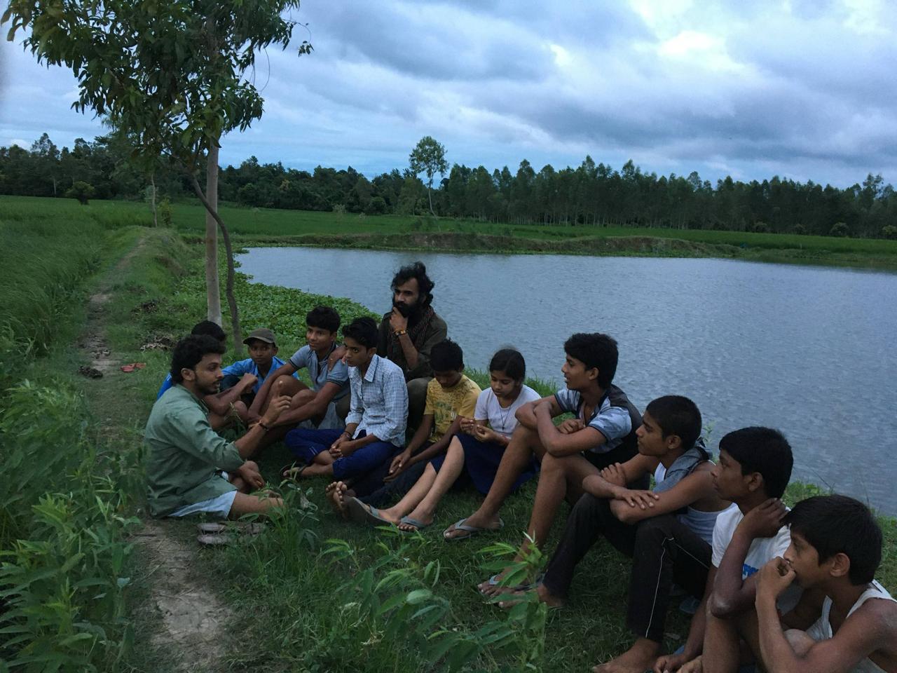 Children planting trees and learning about environmental conservation in outdoor workshop
